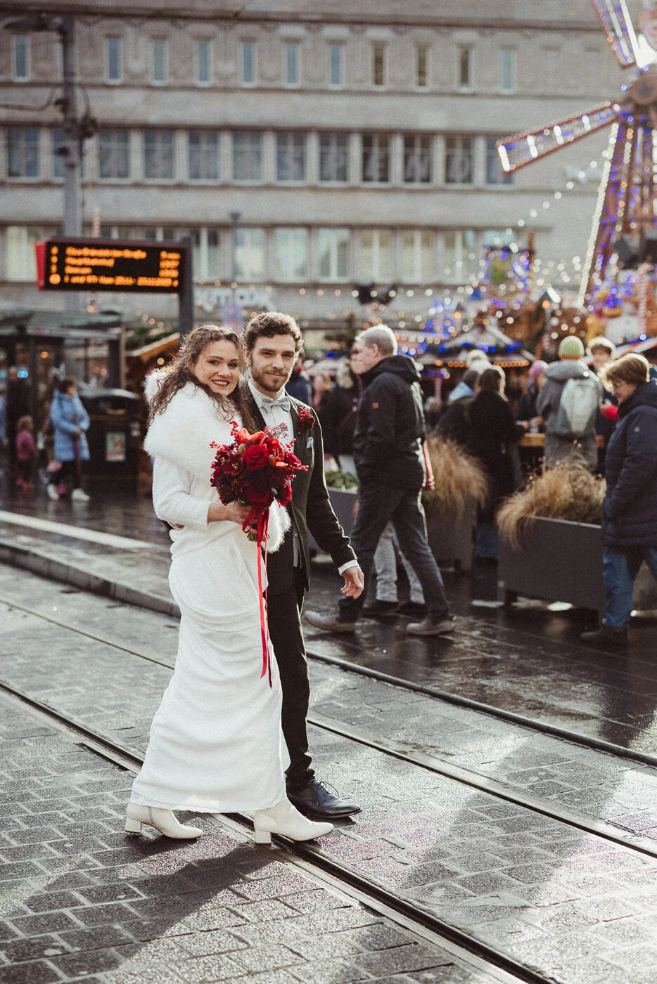 Brautpaar auf dem Weihnachtsmarkt mit rotem Brautstrauss - Winterhochzeit in Halle, geplant von CisaBella